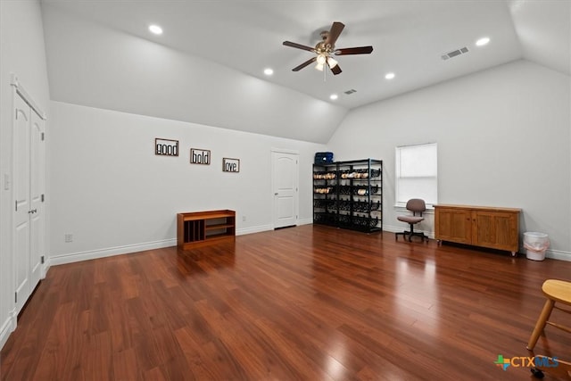 interior space featuring ceiling fan, vaulted ceiling, and dark wood-type flooring