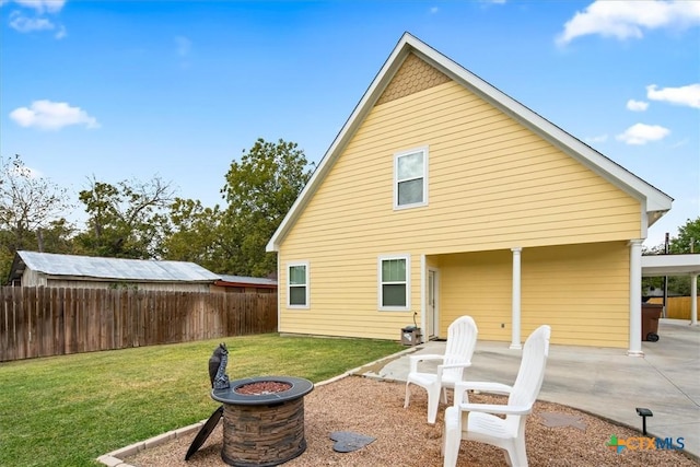 back of house with a patio area, a lawn, and a fire pit