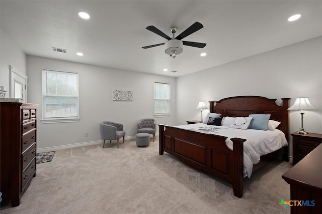 bedroom featuring multiple windows, ceiling fan, and light colored carpet