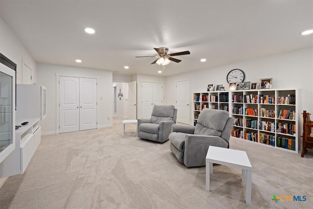 sitting room with ceiling fan and light carpet