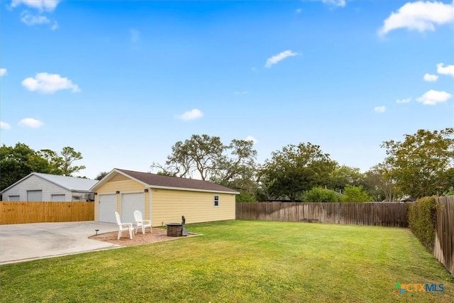 view of yard featuring a garage and an outbuilding