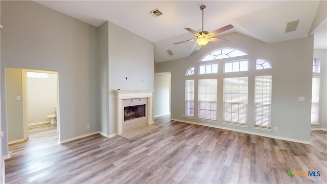 205 Crosswind Dr, Victoria, TX 77904 - unfurnished living room with ceiling fan, high vaulted ceiling, a tile fireplace, wood finished floors, and baseboards