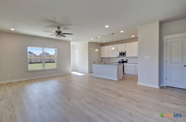 kitchen featuring appliances with stainless steel finishes, ceiling fan, decorative light fixtures, light hardwood / wood-style flooring, and white cabinetry