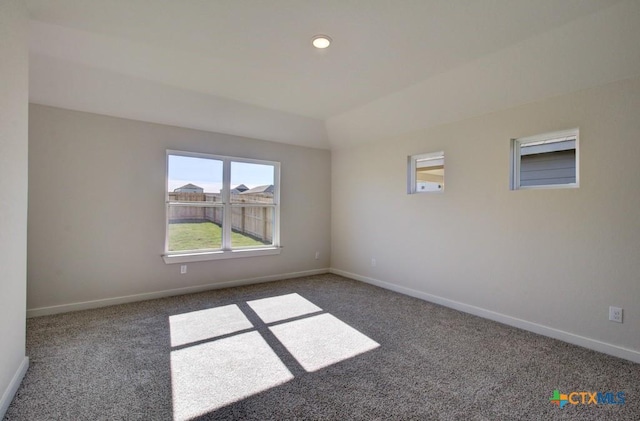 unfurnished room with carpet floors and vaulted ceiling