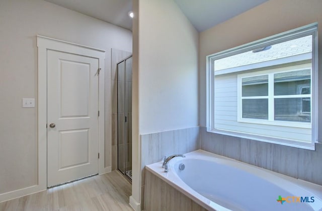 bathroom featuring shower with separate bathtub