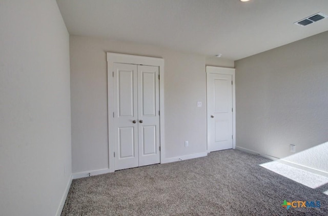 unfurnished bedroom with carpet flooring and a closet