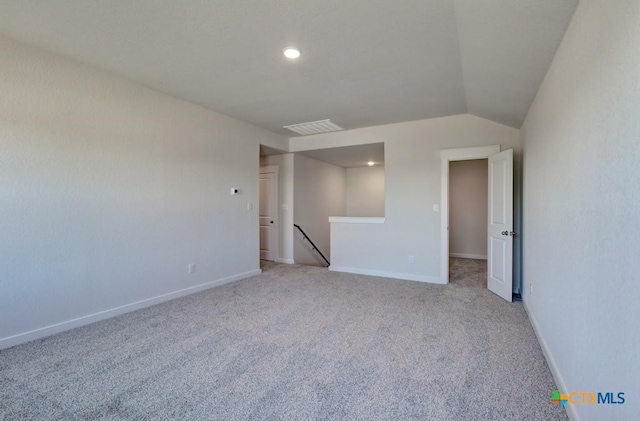 unfurnished room with light carpet and lofted ceiling