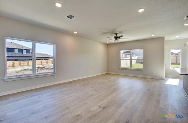 spare room with light wood-type flooring and ceiling fan