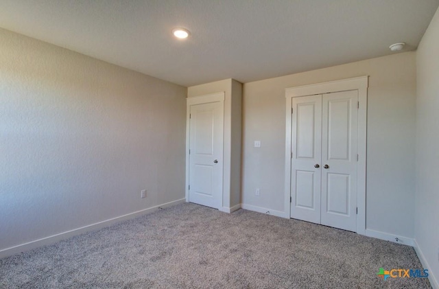 unfurnished bedroom with light carpet and a closet