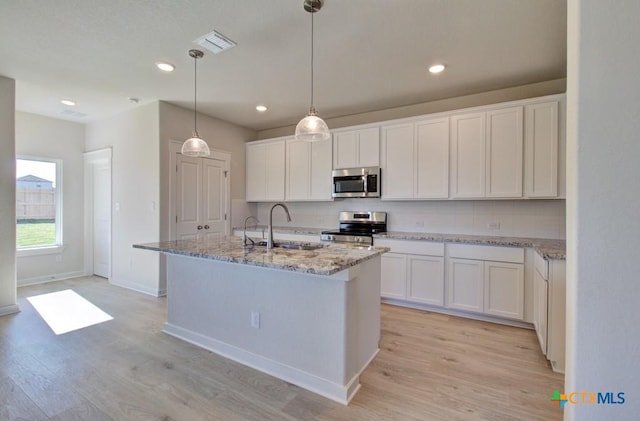 kitchen featuring white cabinetry, sink, an island with sink, and stainless steel appliances