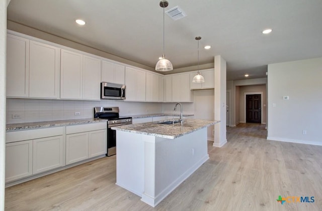 kitchen featuring light stone countertops, sink, white cabinetry, and stainless steel appliances