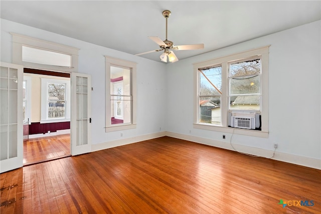 spare room featuring cooling unit, ceiling fan, french doors, and hardwood / wood-style flooring