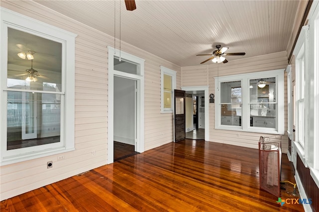 unfurnished sunroom with ceiling fan