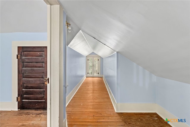 corridor featuring lofted ceiling and hardwood / wood-style floors