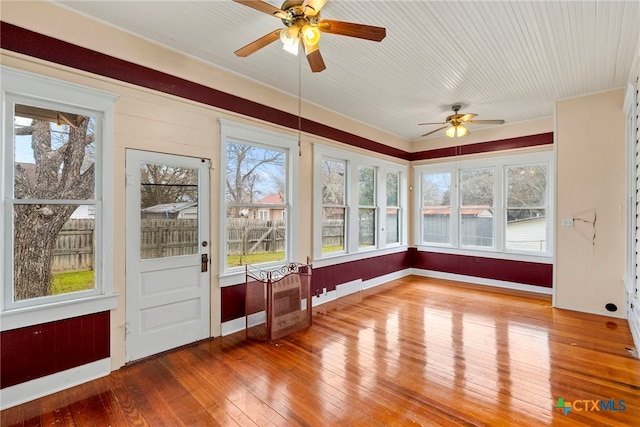 unfurnished sunroom featuring ceiling fan