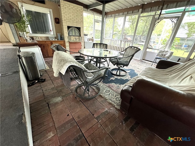 sunroom featuring a fireplace and beam ceiling