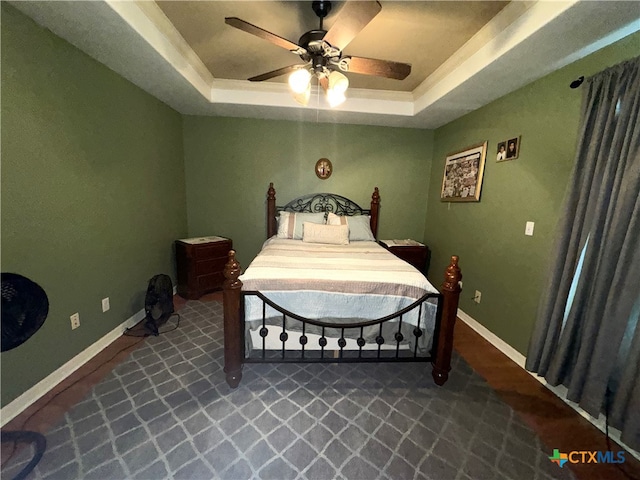 bedroom featuring ceiling fan and a tray ceiling