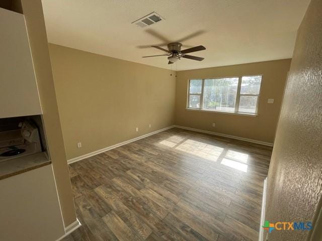 empty room with ceiling fan and dark hardwood / wood-style flooring