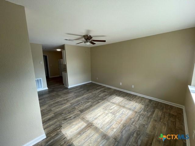 spare room featuring ceiling fan and dark hardwood / wood-style floors