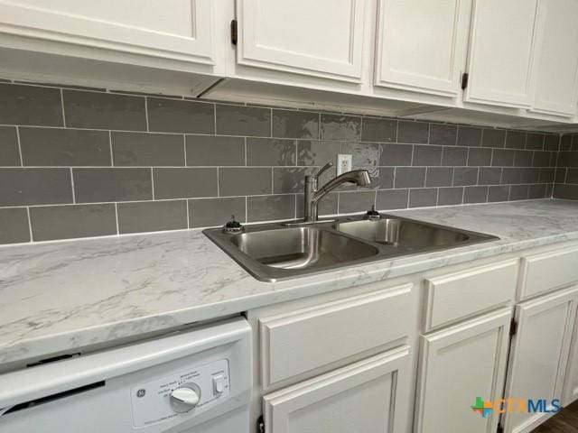 kitchen featuring light stone countertops, white dishwasher, white cabinets, backsplash, and sink