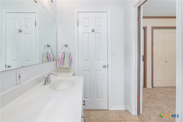 bathroom featuring tile patterned flooring, vanity, and crown molding