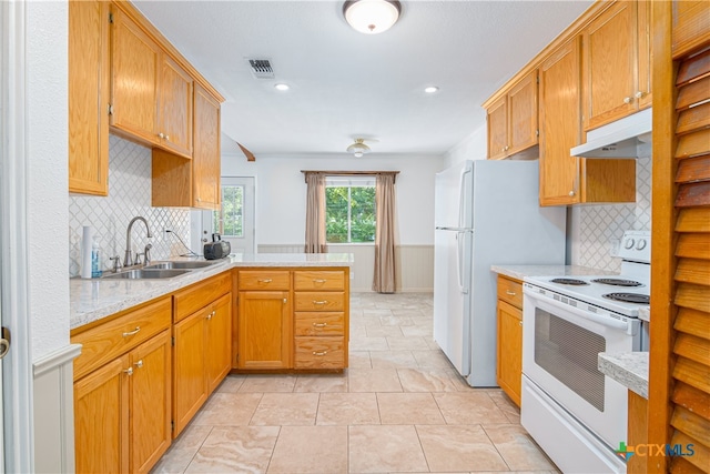 kitchen featuring kitchen peninsula, sink, backsplash, light stone countertops, and white electric range