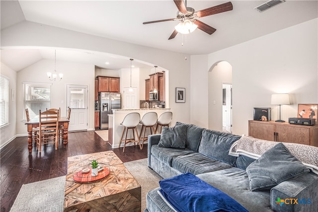 living room with vaulted ceiling, dark hardwood / wood-style floors, and ceiling fan with notable chandelier