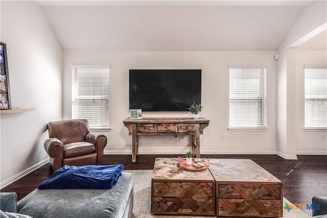 living room with dark wood-type flooring, plenty of natural light, and vaulted ceiling