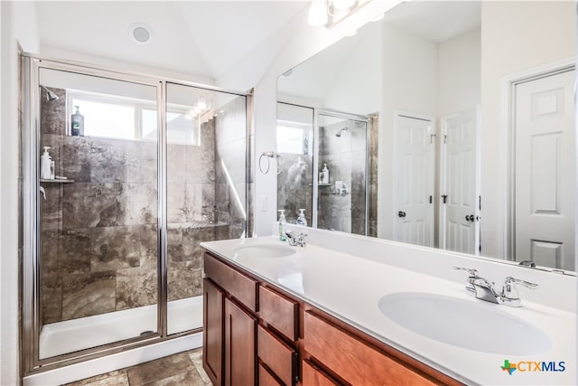 bathroom with walk in shower, vanity, and lofted ceiling