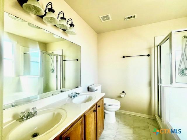 bathroom with vanity, toilet, and an enclosed shower