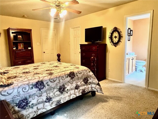 bedroom with ceiling fan, carpet, and ensuite bathroom