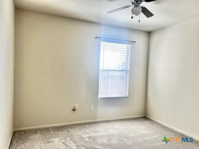 unfurnished room featuring ceiling fan and carpet flooring