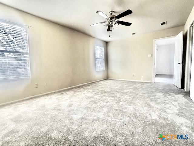 carpeted empty room featuring ceiling fan