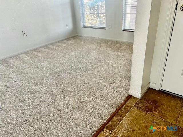 spare room featuring dark colored carpet