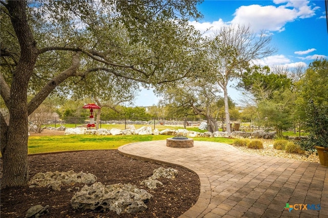 surrounding community with an outdoor fire pit, a patio, and fence