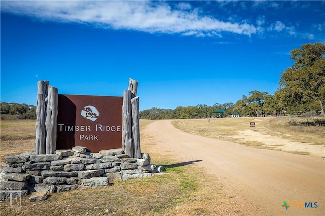 community sign with dirt driveway