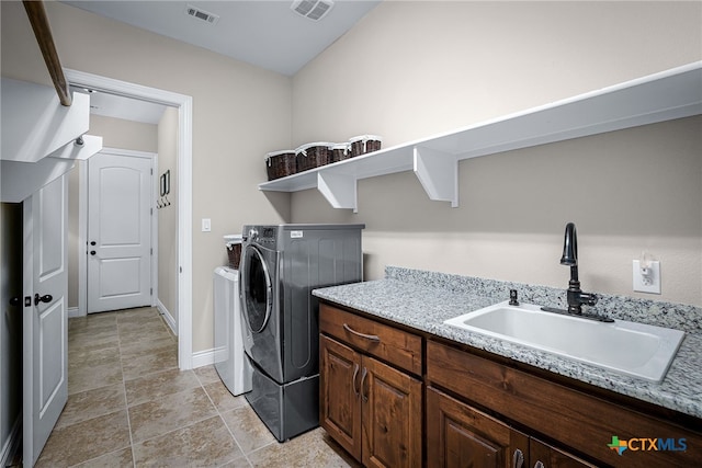 laundry room with baseboards, washing machine and dryer, visible vents, and a sink