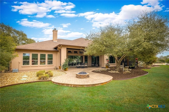 rear view of house featuring a fire pit, a lawn, a patio, a chimney, and stucco siding