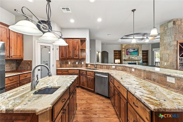 2299 Sun Chase Blvd, New Braunfels, TX 78130 - kitchen with dishwasher, a ceiling fan, light wood-style floors, a large fireplace, and backsplash