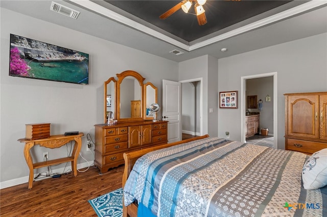 2299 Sun Chase Blvd, New Braunfels, TX 78130 - bedroom featuring a raised ceiling, wood finished floors, a ceiling fan, and ensuite bathroom
