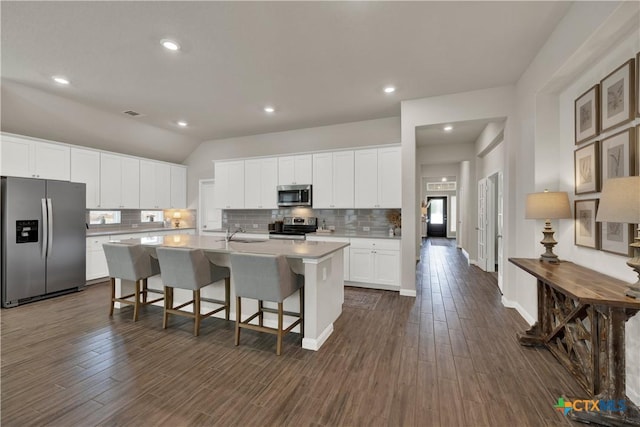 6010 Ballast Trl, New Braunfels, TX 78132 - kitchen featuring stainless steel appliances, decorative backsplash, a center island with sink, dark wood finished floors, and recessed lighting
