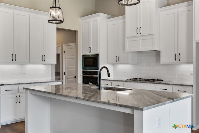 kitchen with white cabinets, sink, and an island with sink