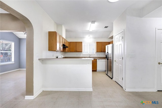 kitchen with stainless steel refrigerator with ice dispenser, a healthy amount of sunlight, dishwasher, and kitchen peninsula