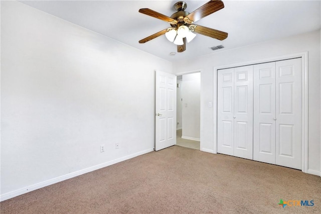 unfurnished bedroom featuring light colored carpet, a closet, and ceiling fan