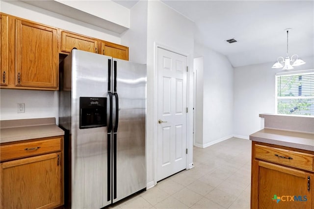 kitchen featuring pendant lighting, stainless steel fridge with ice dispenser, and a notable chandelier