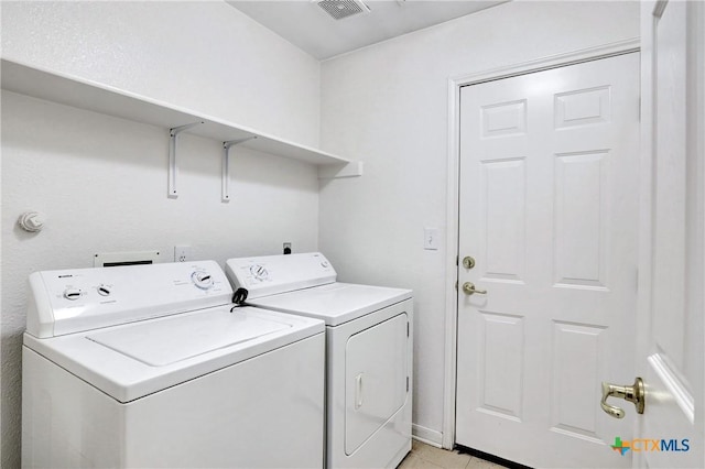 washroom featuring washing machine and clothes dryer and light tile patterned floors