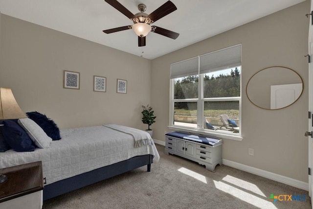 bedroom with ceiling fan, baseboards, and light carpet