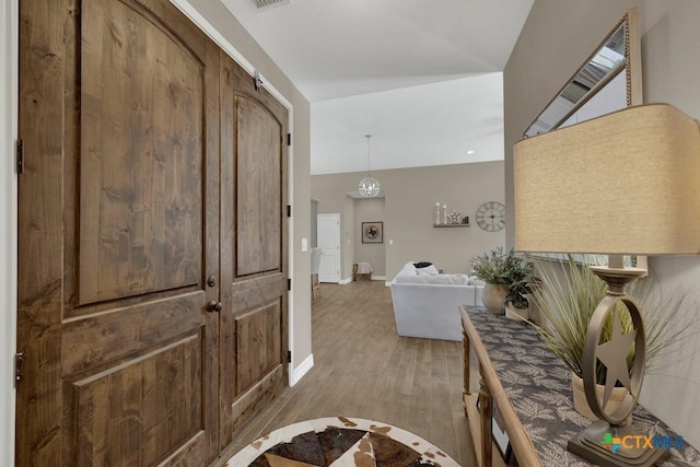 interior space featuring baseboards, wood finished floors, and visible vents