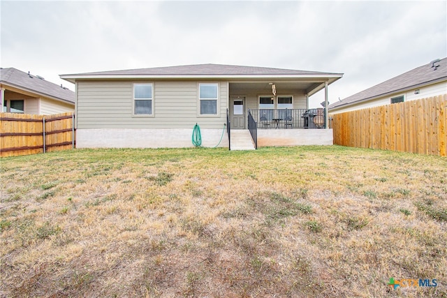 rear view of property featuring a lawn and a patio