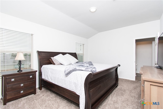 bedroom featuring light carpet and vaulted ceiling